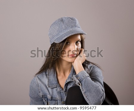 A brunette model in denim jacket and cap