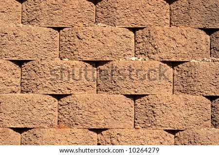An interlocking retaining wall of red cement blocks