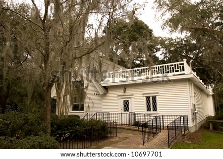An old southern church amongst oak trees draped with spanish moss