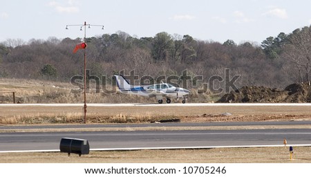A small private blue and white plane on a runway at a regional airport