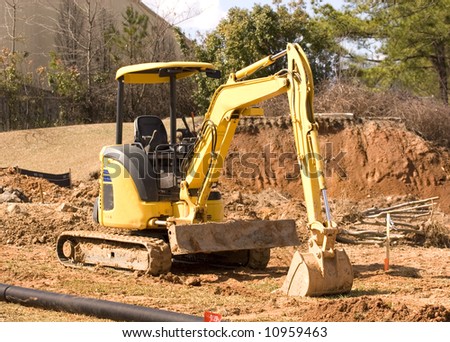 A yellow front end loader working a dirt construction site