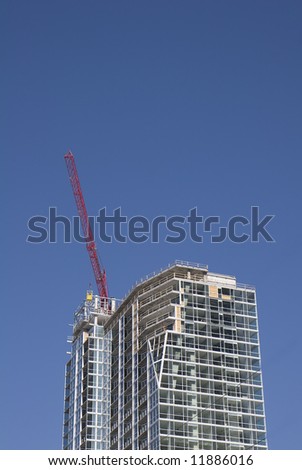 A red crane atop a new tower construction project