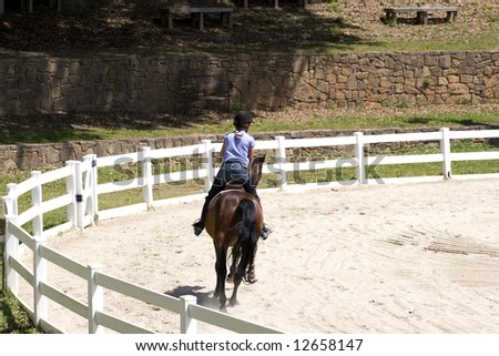 A young woman riding a horse on a jumping course