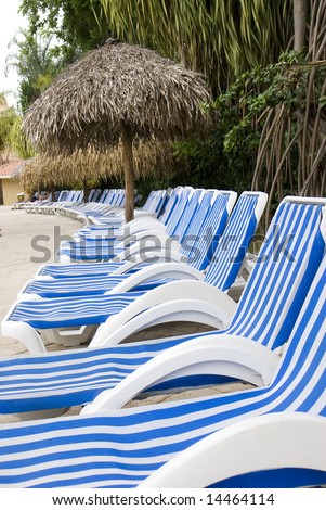 Blue and white striped lounge chairs around a luxury resort swimming pool