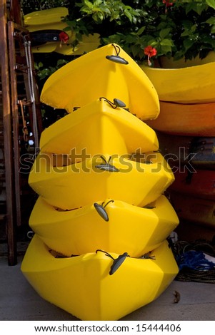 Five yellow kayaks stacked at a boat rental