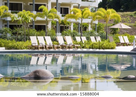 Stones in a resort pool with white chaise lounges