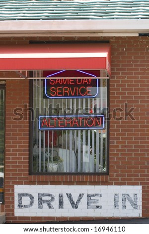Neon signs on a dry cleaner drive in window