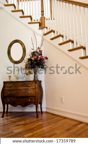 A nice foyer by interior stairs with table and flowers