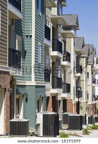 A row of townhouses with air conditioner compressors outside each one