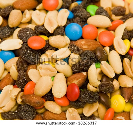 A shot of trail mix including nuts, raisins, and candy covered chocolate