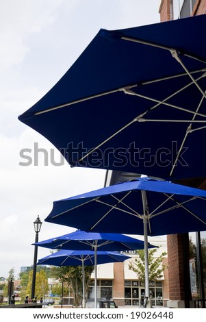 Rows of blue sun umbrellas outside a restaurant