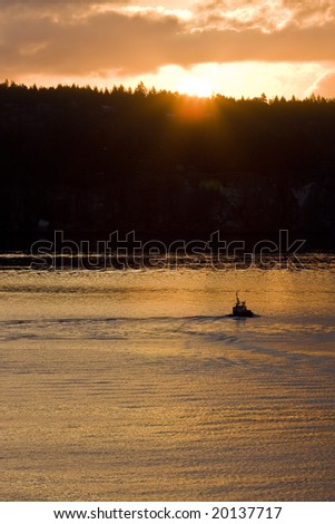 A tugboat heading east into the rising sun