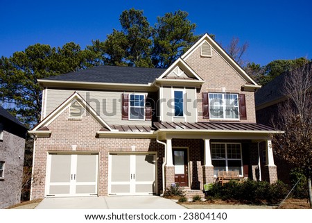 A light brown brick house under a deep blue sky