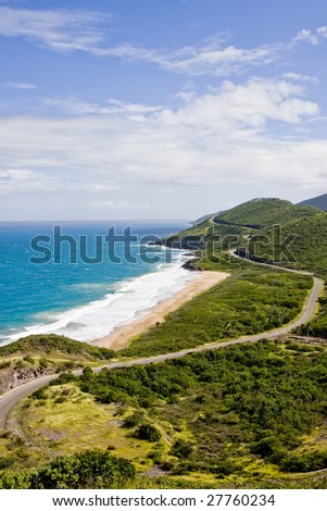 Deep Blue Sea and Green Hills under Blue Sky and Clouds