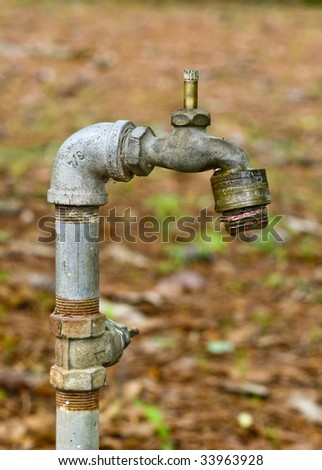Closeup of an old iron water spout in a forest
