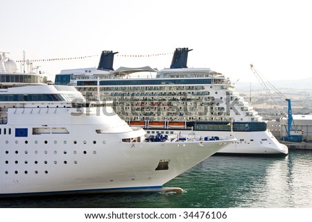 Two cruise ships anchored in a busy port