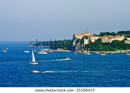 An old French fortress on an island off the coast of Cannes with pleasure boats in the blue water of the Mediterranean