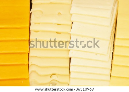 Four kinds of sliced cheeses at a deli counter