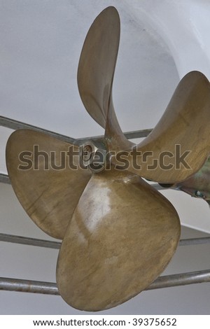 A brass propeller on the bottom of a white boat