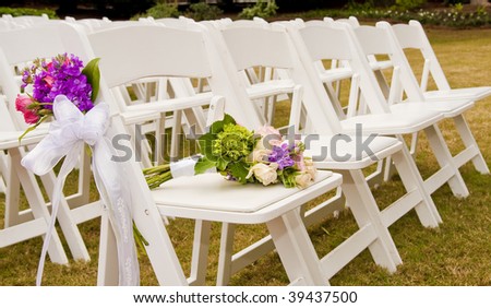White Folding Chairs At An Outdoor Wedding With Flowers Stock ...