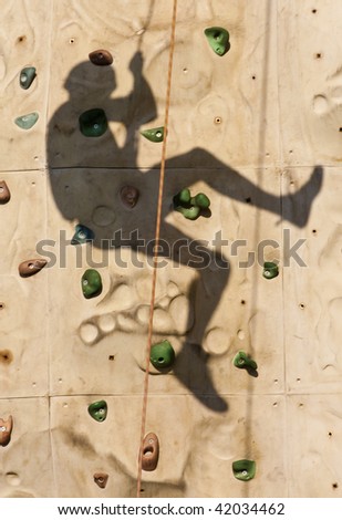 Shadow of a person climbing on a rock wall