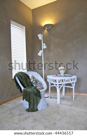 Corner of a den or living room with a chair, table, and lamp