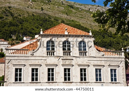A huge old stone villa with red tile roof on a hillside above Dubrovnik