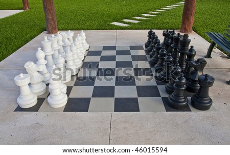 A giant chess set on a board at a park