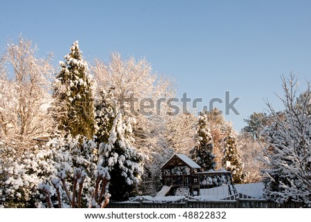 Snow in a residential yard and playground under blue sky