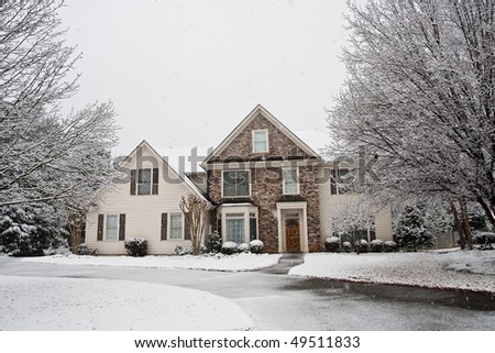 A nice house of stone and siding in the snow