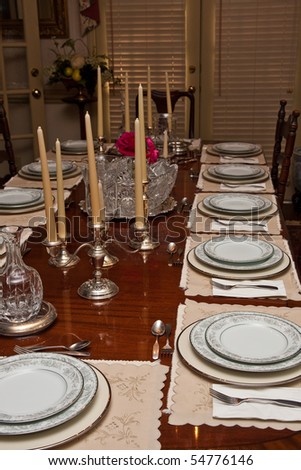 A formal dinner table set with china and crystal