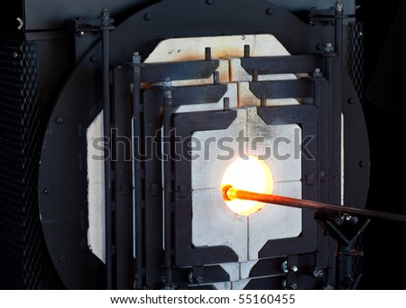 A glass blowing rod firing glass in an oven