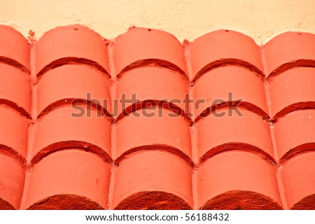 A red tile roof on an orange stucco building