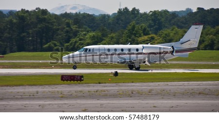 A large private jet landing on a regional runway