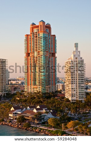 A tall rose colored condo tower rising in the dawn light at Miami Beach