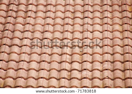 An old dirty curved red tile roof