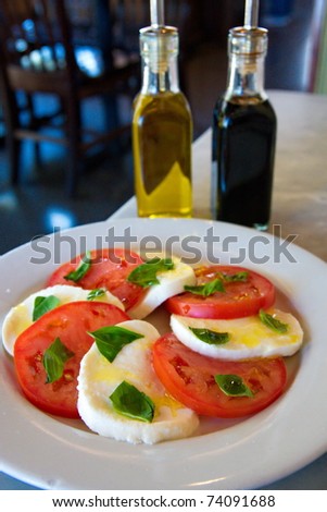 A salad of fresh sliced tomatoes and mozzarella cheese with olive oil and balsamic vinegar