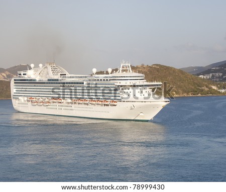 A huge white luxury cruise ship anchored in a bay off St. Thomas island in the Caribbean