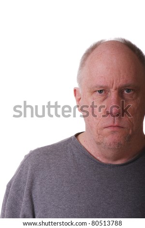 An older balding man in gray shirt looking grumpy or mad