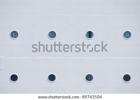 Portholes on the side of a white cruise ship