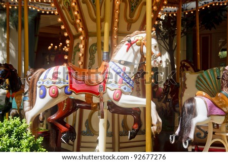 A carousel with a white horse in a public park