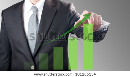 Business man pointing at green bar chart for business growth concept