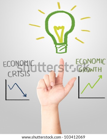 and pointing to the hand draw light bulb with falling and rising graph for economic crisis or growth concept