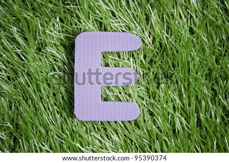 One letter of foam on green grass field