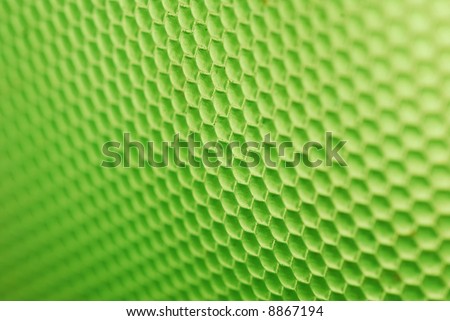 marco shot of a bee hive shaped background in green