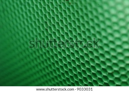 marco shot of a bee hive shaped background in green