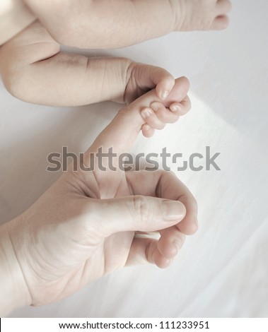 baby\'s hand gripping parent\'s hand