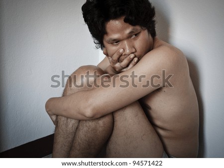 Scared Asian Man Naked And Sitting In A Dark Corner