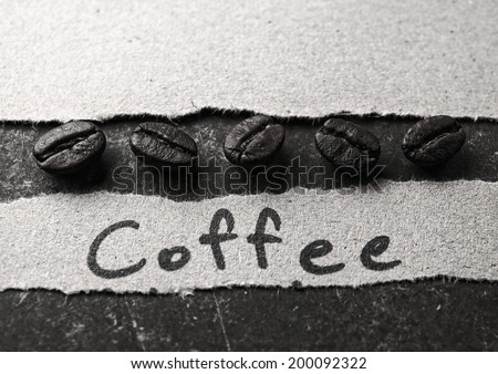 Coffee crop beans with paper on wood texture, monotone background