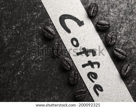 Coffee crop beans with paper on wood texture, monotone background